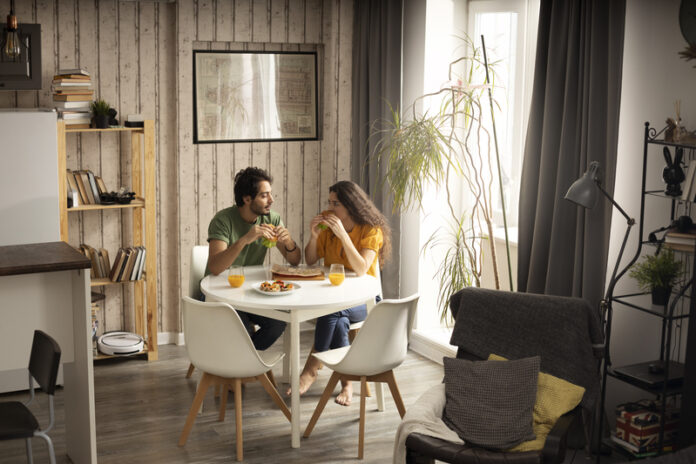 Casal sentado em uma sala em seu primeiro apartamento.